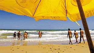 Banhistas aproveitam o mar e o sol de Massarandupi, praia no norte da Bahia que recebe diariamente 200 casais de naturistas